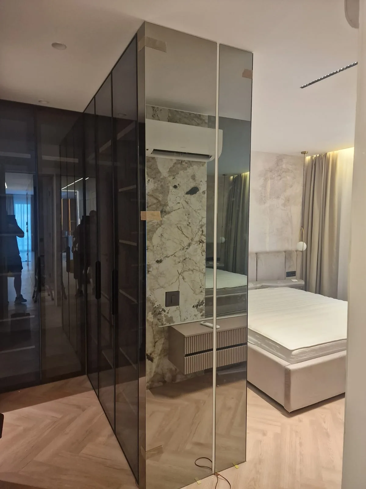 Stijena od sivog zatamnjenog stakla oko garderobe u spavaćoj sobi